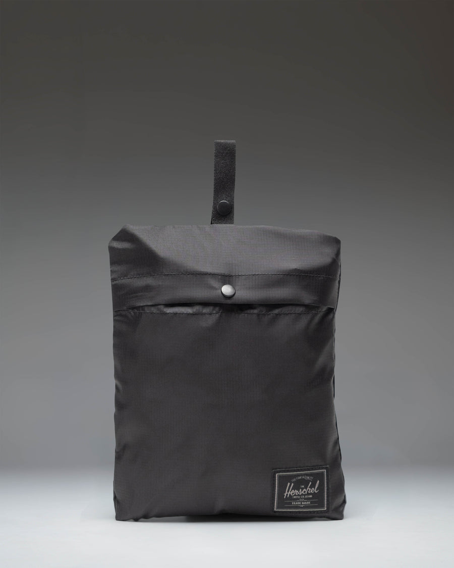 Herschel Supply Co. Portland Packable Tote bag in Black Tonal folded neatly into its internal storage pocket showing the screenprinted logo.
