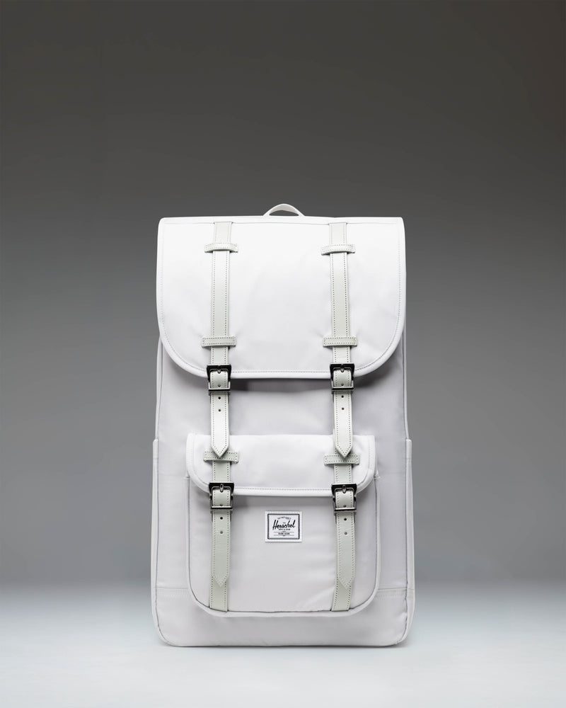 Herschel Little America Backpack in Metal grey, featuring a front pocket with strap details, a top flap closure, and padded shoulder straps.