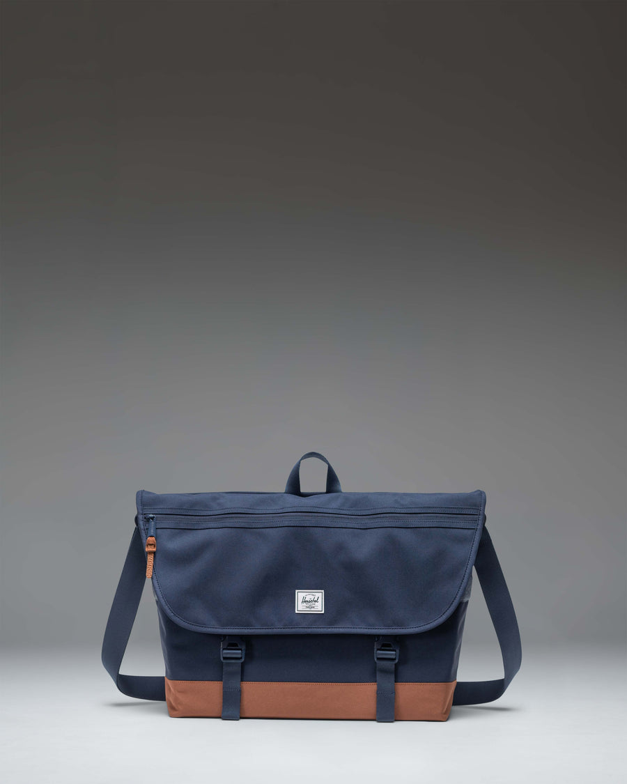 Herschel Supply Co Cove Messenger bag in navy blue with saddle brown straps and accents.
