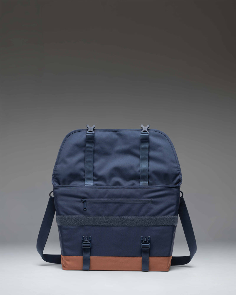 Herschel Supply Co Cove Messenger bag in navy blue with a saddle brown bottom and strap details.
