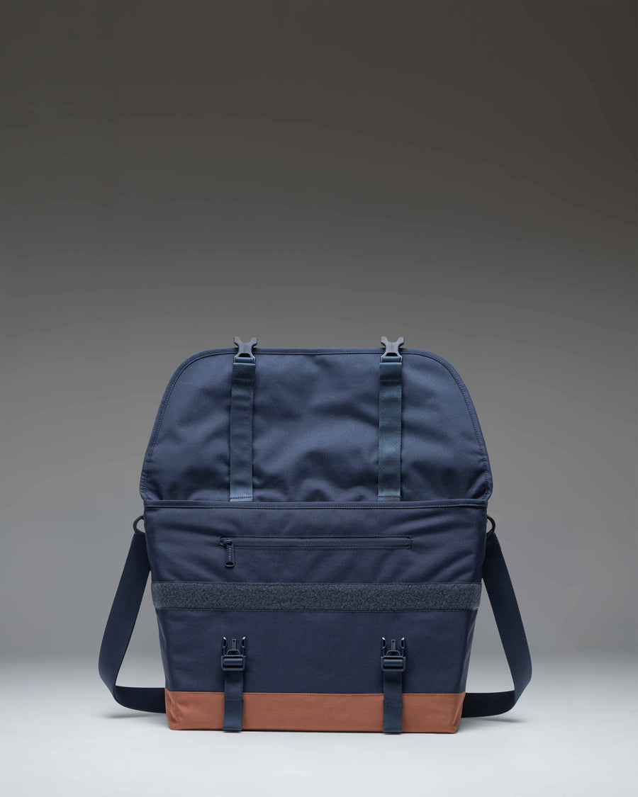 Herschel Supply Co Cove Messenger bag in navy blue with a saddle brown bottom and strap details.