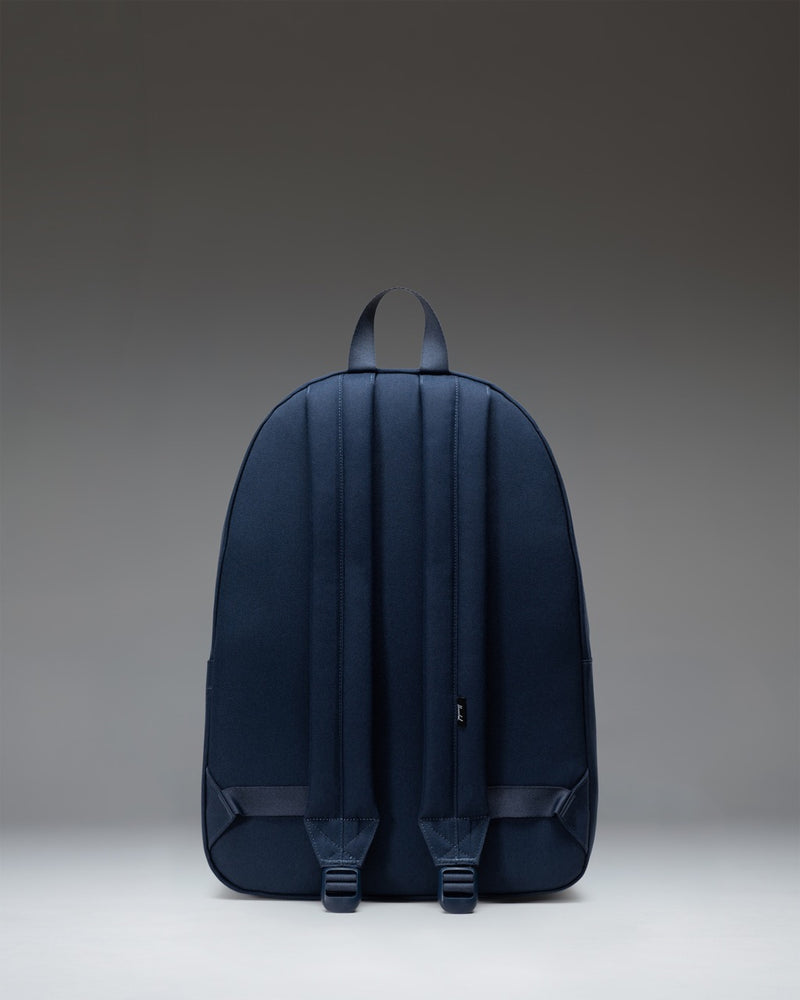 Navy blue Herschel Classic XL Backpack featuring a clean, minimalist design with a front zippered pocket and padded shoulder straps.