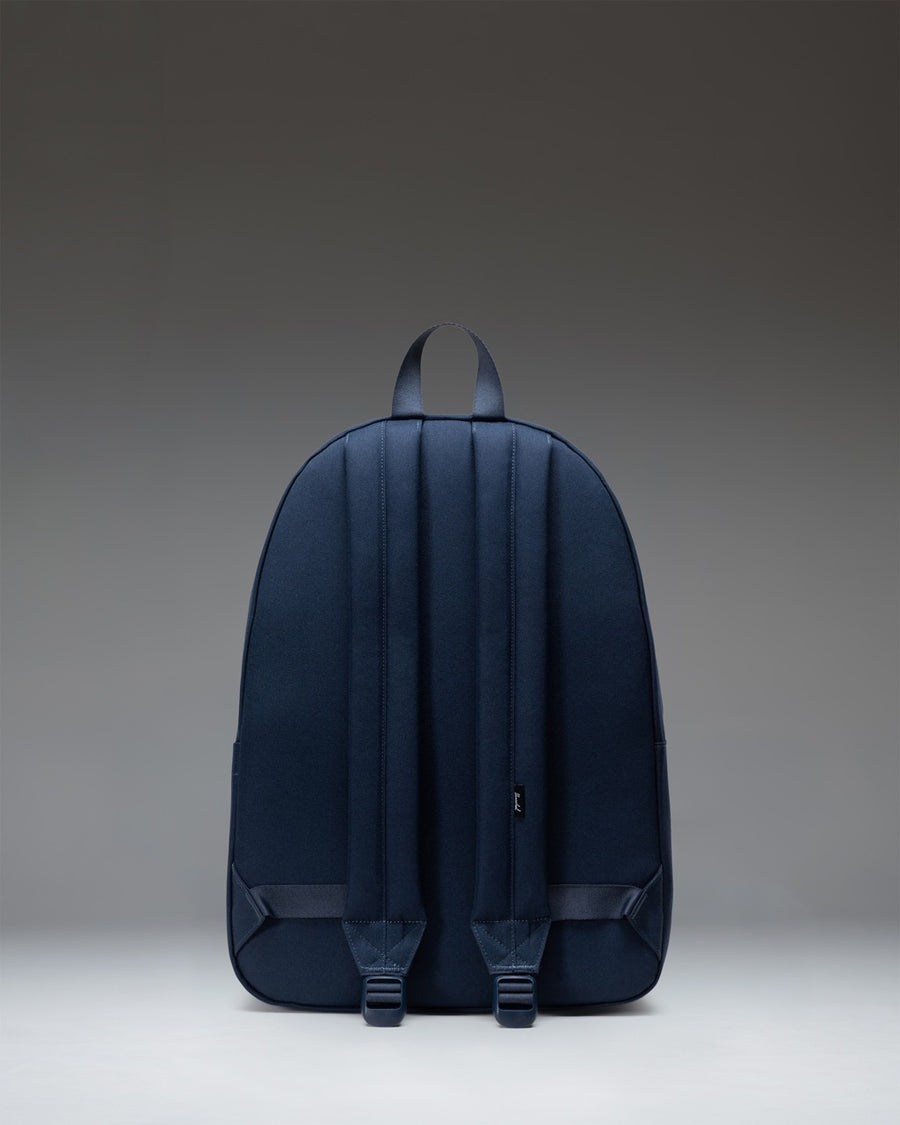 Navy blue Herschel Classic XL Backpack featuring a clean, minimalist design with a front zippered pocket and padded shoulder straps.