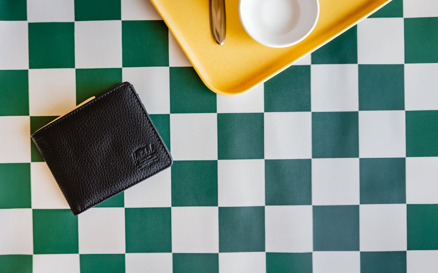 Herschel Supply Co. Roy Wallet in black vegan leather shown from a front angle on a plain white background.