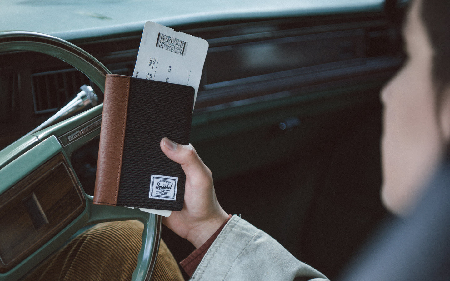 Black pebbled vegan leather Raynor Passport Holder by Herschel Supply Co. with card slots and a passport sleeve.