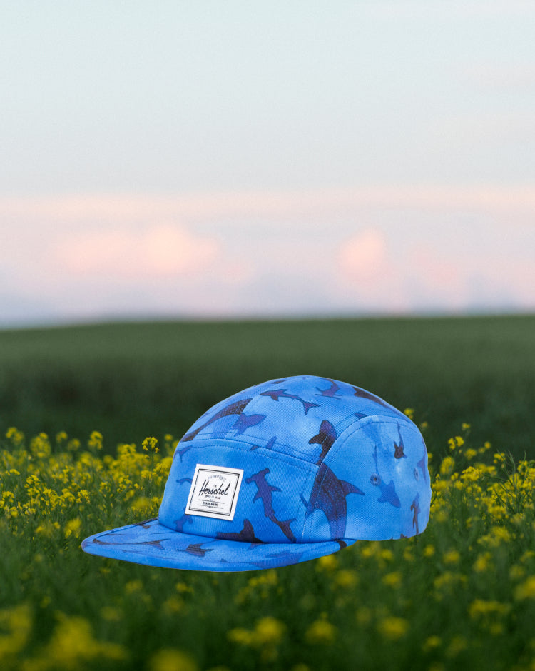 Herschel Supply Co. Glendale Kids Cap in Sharks, featuring a blue five-panel cap with an all-over shark pattern.