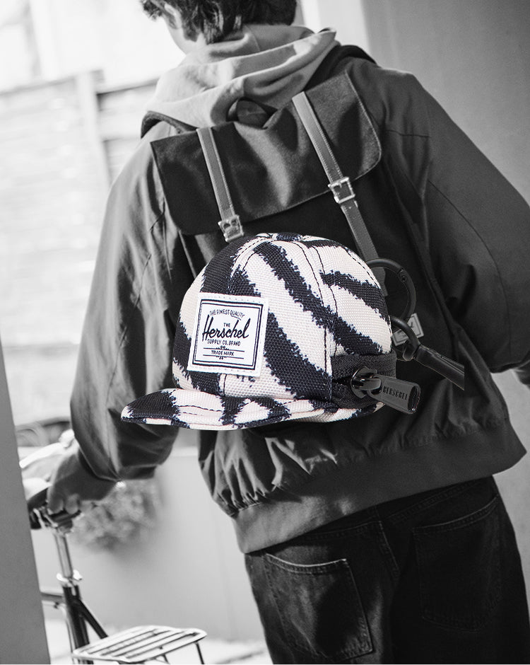 Herschel Supply Co. Sylas Classic Cap Bag Charm in a striking black and white zebra print pattern.