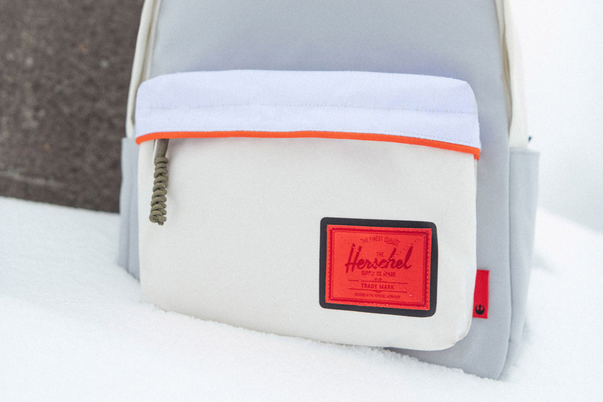 classic xl backpack with a bright red classic woven label sits on a snowy surface