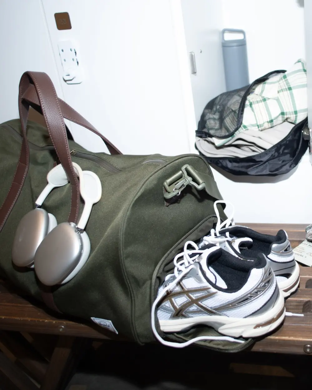 A photo of the man getting out of a car holding a black Herschel Novel™ Duffle.