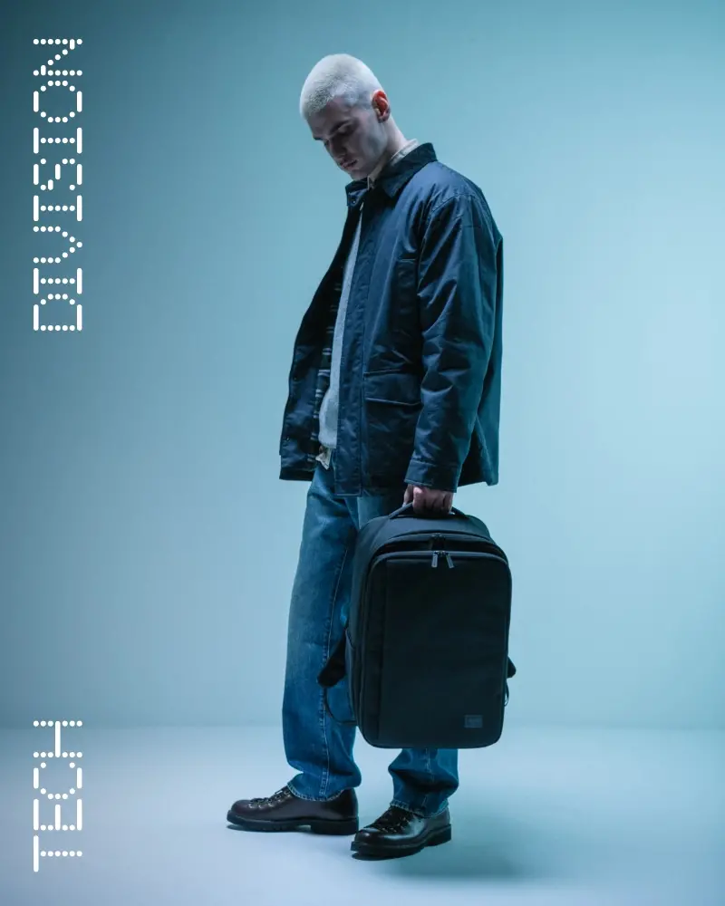 A photo of the man getting out of a car holding a black Herschel Novel™ Duffle.